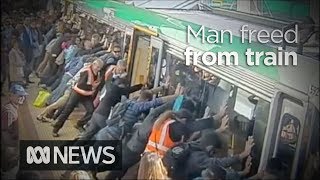 Faith in humanity restored as crowd lift train to save trapped man 2014  ABC News [upl. by Notsag]